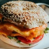Bacon Brekkie Sando · 2 cage-free scrambled eggs, mild cheddar cheese, arugula and tomatoes on a sesame seed bagel...