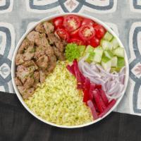 Beef Shawarma Bowl · Tender beef shawarma over rice and topped with spicy red sauce. Served with our cucumber and...