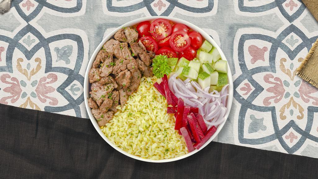 Beef Shawarma Bowl · Tender beef shawarma over rice and topped with spicy red sauce. Served with our cucumber and tomato salad, leafy greens, white sauce, and a side of pita.