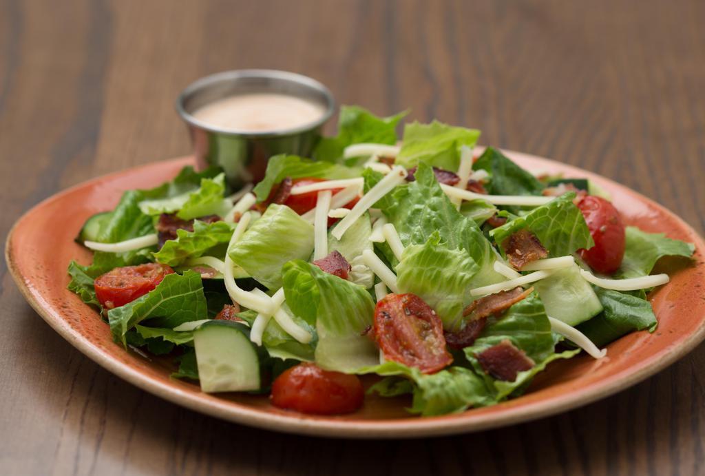 House Chop Salad · Romaine blend, bacon, cucumber, roasted tomatoes, White Cheddar cheese, BBQ onion ranch dressing.