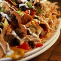 Nachos · Tortilla chips topped with refried beans, queso sauce, shredded cheese, black olives, diced ...