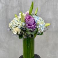 Whimsical Love · Hydrangeas, roses, white lilies, blue thisle and cabbage all hand-arranged in a tall glass v...