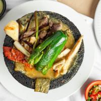 Molcajete El Rinconcito · Steak, shrimp, grilled chicken, chorizo, deeped in a special sauce, garnished with cactus, q...