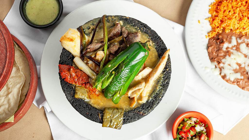 Molcajete El Rinconcito · Steak, shrimp, grilled chicken, chorizo, deeped in a special sauce, garnished with cactus, queso fresco, jalapeno, sour cream, and guacamole.