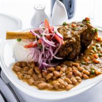 Seco De Cordero Con Frijoles · Lamb hind shank braised in a cilantro sauce, served with jasmine rice, Peruvians beans and s...