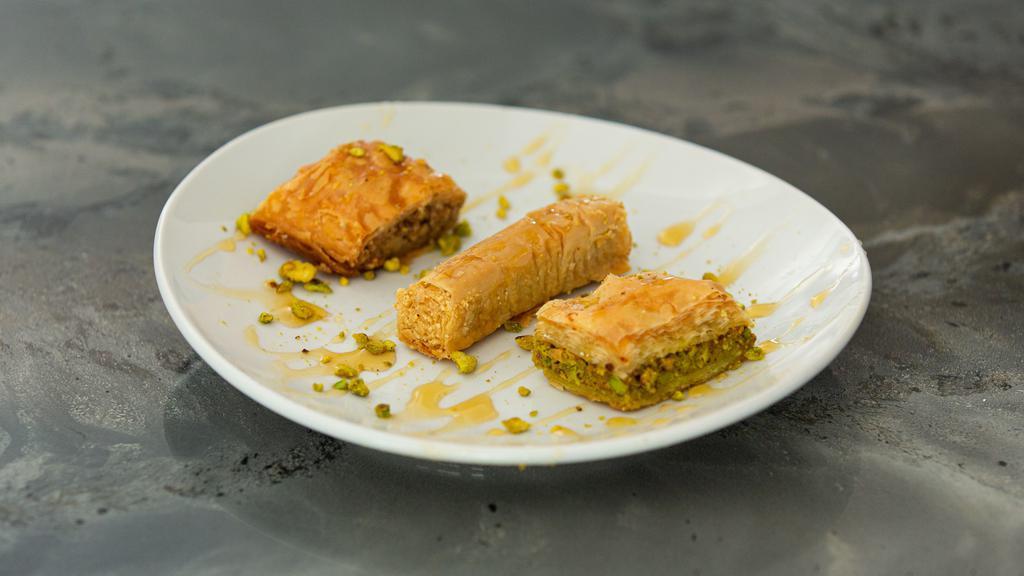 Baklava · An assortment of three traditional delicacies made with many layers of filo dough, lightly buttered, and drizzled with honey syrup.