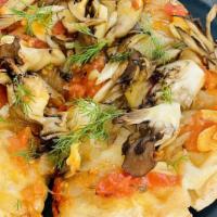 Maitake Flatbread · Maitake mushrooms, onion jam, arugula, tomato confit, on low gluten Pinsa crust.  VEGAN