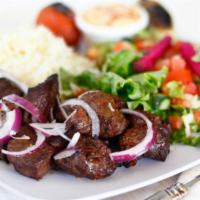 Beef Shish Kabob · Marinated beef served with hummus, rice, salad, onion, and pita bread.