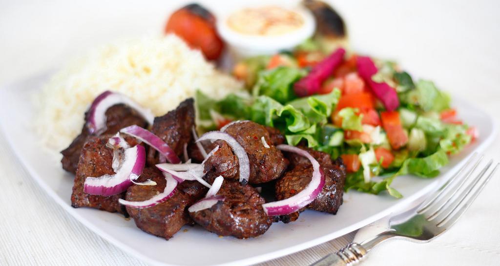 Beef Shish Kabob · Marinated beef served with hummus, rice, salad,  and pita bread.