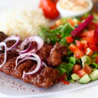 Beef Lula Kabob · Ground served with hummus, rice, salad, onion, and pita bread.