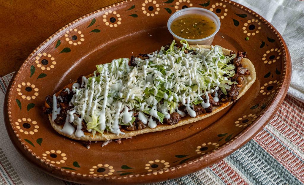 Huarache · Large fried thick corn tortilla, choice of meat, refried beans, lettuce, cheese, sour cream, onions, cilantro, salsa