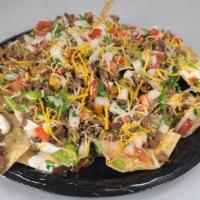 Super Nachos · Most popular. Choice of meat, with guacamole, sour cream, pico, beans and cheese.