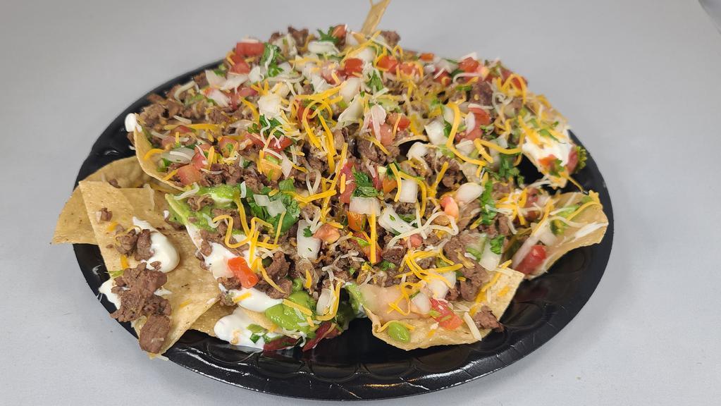 Super Nachos · Most popular. Choice of meat, with guacamole, sour cream, pico, beans and cheese.