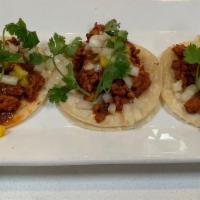 Al Pastor Tacos · Three large tortillas filled with roasted chunks of pork that is marinated in a house made g...