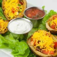 California Skins · Potato skins filled with bacon, cheddar, tomatoes and scallions. Served with sour cream and ...