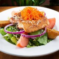 Grilled Salmon Salad · Salmon on a bed of romaine lettuce with red potatoes, tomatoes and rings of red onions. Topp...