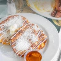 Cinnamon Roll French Toast Combo · A whole cinnamon roll dipped in French toast batter, topped with white icing & dusted with p...