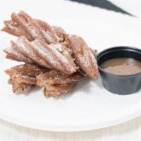 Churro Dunker · A churro in one hand and a choice of dipping sauce in the other.