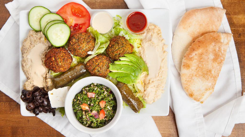 Super Falafel Plate · A delicious mixture of garbenzo beans, herbs, and spices, served with tahini, lettuce, tomato, hummus, baba ganoush (eggplant), and tabouli, dolma, feta, avocado, cucumber, and an extra falafel ball.