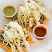 Sope · 1 fried thicker  home made corn tortilla, meat, beans, lettuce, Mexican cheese & sour cream