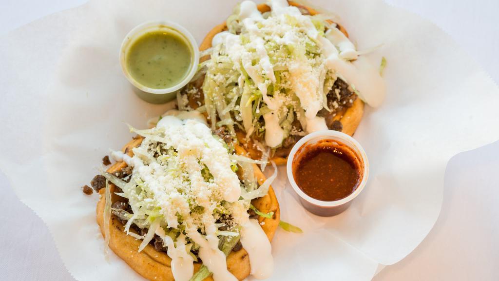 Sope · 1 fried thicker  home made corn tortilla, meat, beans, lettuce, Mexican cheese & sour cream