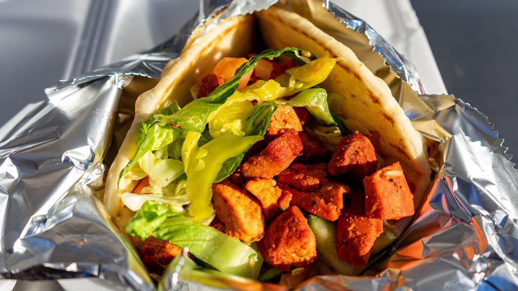 Chicken Gyro · Chicken breast and chicken thighs marinated together in our secret sauce served on Pita with lettuce, cucumbers, tomatoes, onions, pepperoncinis topped off with homemade tzitiki sauce, white sauce and hot sauce.