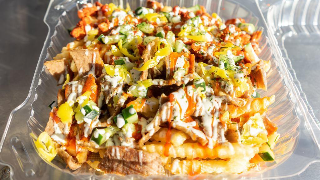 Habibi'S Fries · The Habibi way -  A mix of our authentic lamb and chicken served on Fries with lettuce, cucumbers, tomatoes, onions, pepperoncinis, and feta cheese topped off with homemade tzitiki sauce, white sauce and hot sauce.