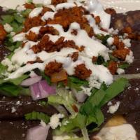 Enfrijoladas · 3 rolled enfrijoladas made with homemade black beans & longaniza sauce. Filled with cheese i...