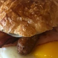 Croissant Combo · Ham, bacon, sausage, eggs, and provolone cheese on a freshly baked croissant.