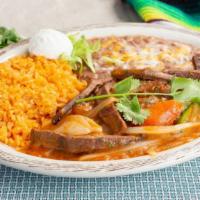 Steak Ranchero · Juicy steak cooked in Ranchero sauce served with rice, beans and sour cream.