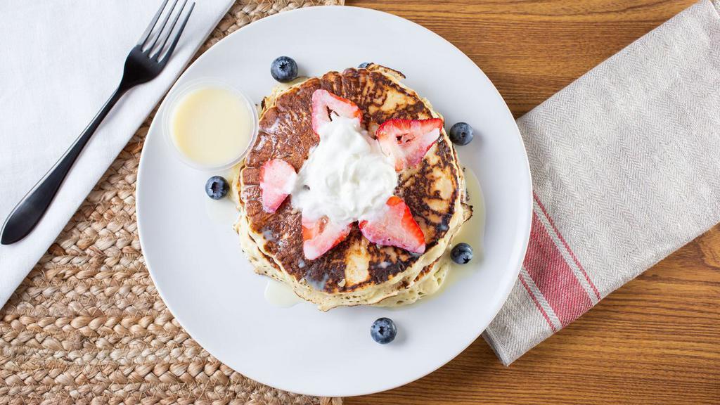 Tres Leches Pancakes · Buttermilk pancakes with fruits, tres leches sauce and whipped cream.