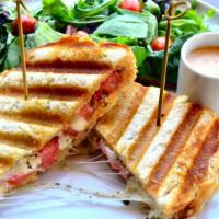 Caprese Panini · Tomatoes, mozzarella, and pesto mayo on sourdough with a side of salad and a side of dressing