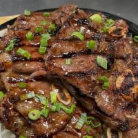 Korean Bbq Short Ribs · Beef short ribs marinated in Korean BBQ sauce, served on a bed of grilled onions, topped wit...