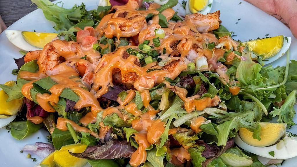 Shrimp Louie Salad · A bed of crispy lettuce topped with Cajun- spiced shrimp, red onions, diced tomatoes, and hard boiled eggs. Served with an our house creamy tomato louie salad dressing.