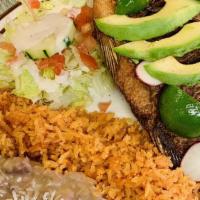 Mojarra Frita Fish · Fried and seasoned fish topped with sliced tomatoes, onions, avocado, and a sprinkle of cila...
