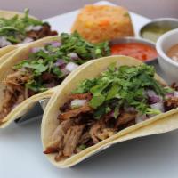 Tacos Carnitas · Three corn tortillas filled with savory fried pork, onions, and cilantro. Served with rice a...