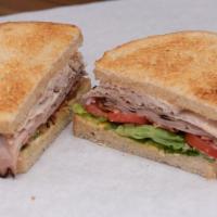 The Club · Black forest ham, thinly sliced turkey breast, crispy bacon, Swiss cheese, mayo, mustard, le...