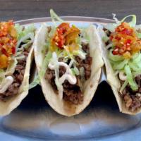 Philly Tacos · Sliced ribeye, white American cheese, caramelized onions, mayo, lettuce, and cherry peppers.