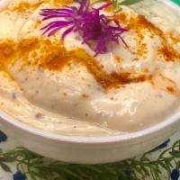 Dahi Vada · Two vadas dipped in yogurt sauce garnished with cilantro.