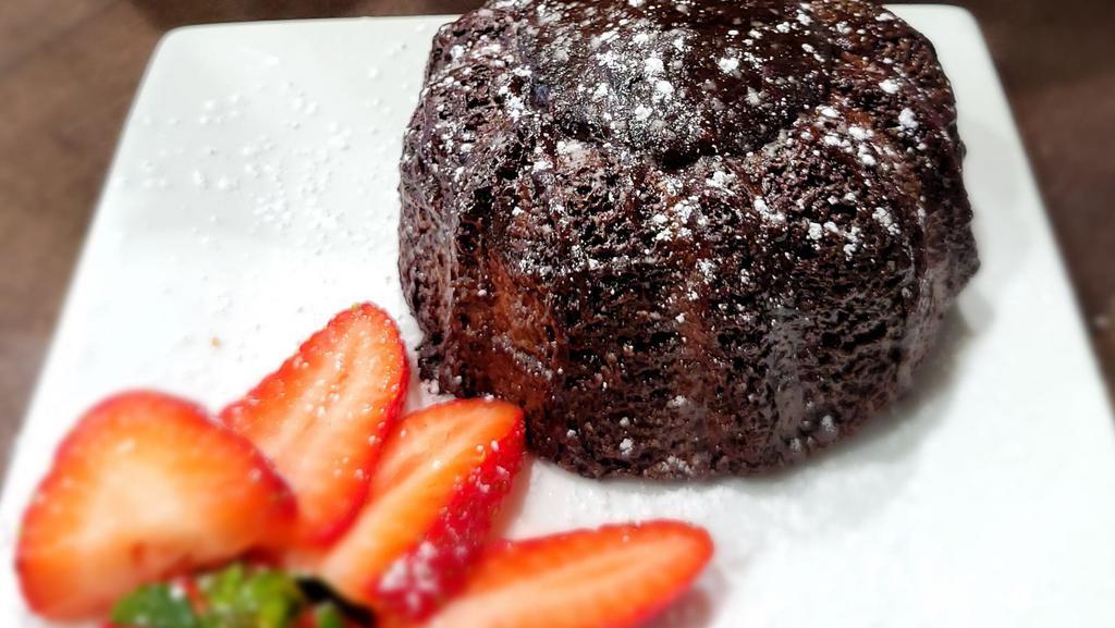 Chocolate Lava Cake  · A warm, fudgy chocolate cake with a molten dark chocolate center. Sprinkled with powdered sugar & strawberries on the side.