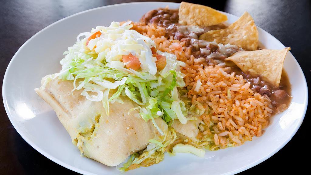 Ranchero Tamale Plate · Two tamales topped with lettuce, tomato, sour cream, and cheese with rice and beans.