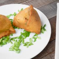 Vegetable Samosas · Two deep fried patties stuffed with potatoes, peas, spices and herbs.
