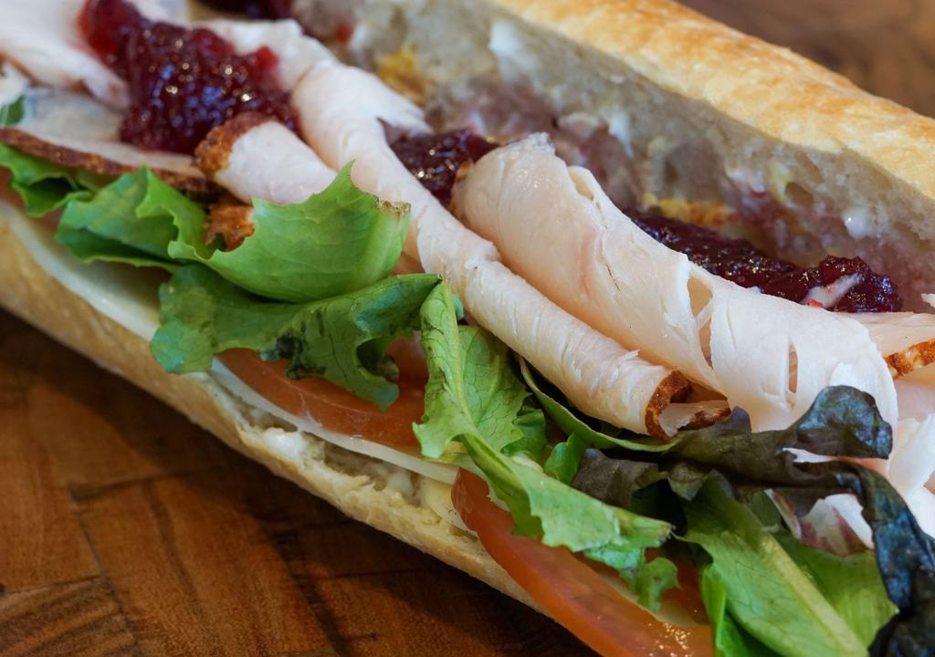 Turkey · Oven roasted turkey, provolone, cranberry sauce, mixed greens, Roma tomatoes, mayo, dijon mustard, on toasted baguette.