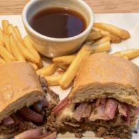Prime Rib French Dip Sandwich · Our house prime rib thinly sliced and stacked with Swiss cheese and sauteed onions on a Fren...