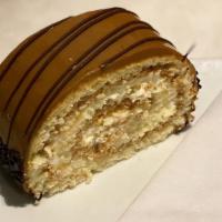 Dulce De Leche Roll · Almond sponge cake rolled with real whipped cream and dulce de leche custard, coated with du...