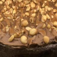 Snickers Cheesecake (Full Cake) · Chocolate Cake separated with think layer of cheesecake topped with peanuts.