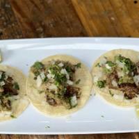 Carnitas Tacos · Three delicious, slow roasted, pork tacos. Topped with cilantro and onion.