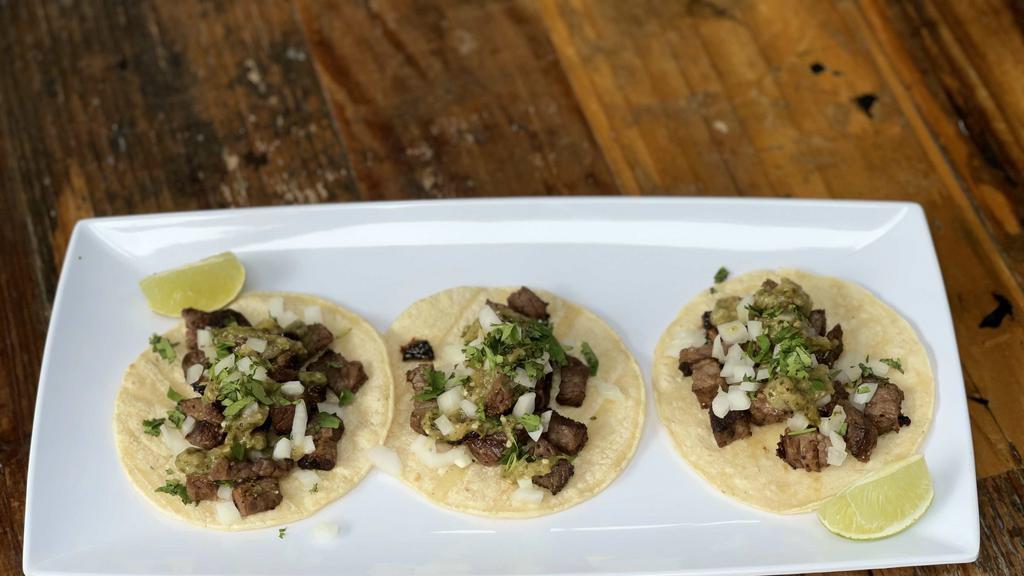 Carne Asada Tacos · Three street style tacos with carne asada, onions and cilantro.
