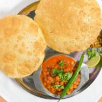 Chana Puri · Chickpeas cooked in Indian gravy and spices, served with puffed bread (puri), achar, salad.