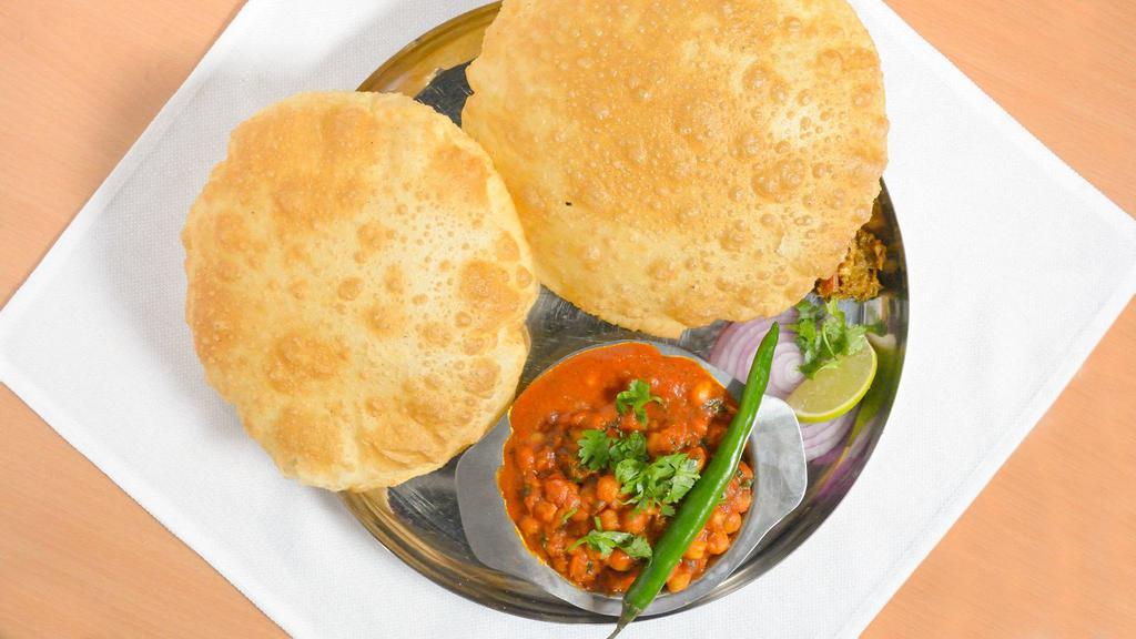 Chana Puri · Chickpeas cooked in Indian gravy and spices, served with puffed bread (puri), achar, salad.